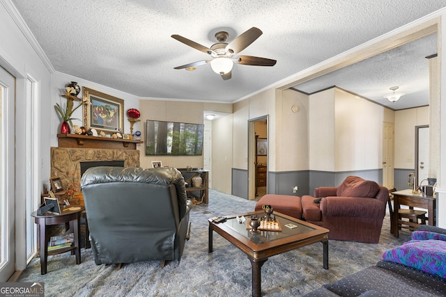 living room featuring crown molding, ceiling fan, a textured ceiling, a fireplace, and a healthy amount of sunlight