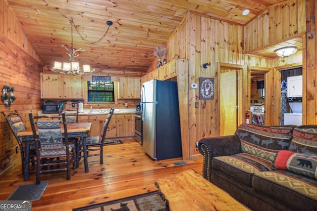 kitchen featuring stainless steel fridge, vaulted ceiling, light brown cabinets, wooden ceiling, and a chandelier