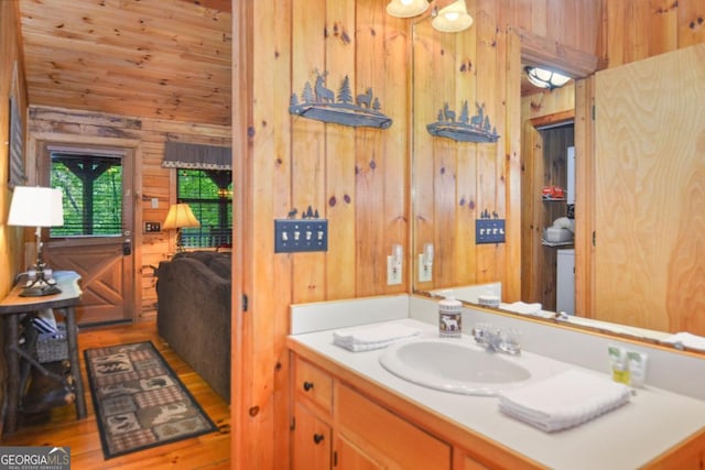 bathroom with hardwood / wood-style floors, vanity, and wooden walls