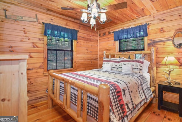 bedroom with wood-type flooring, ceiling fan, wood walls, and wood ceiling