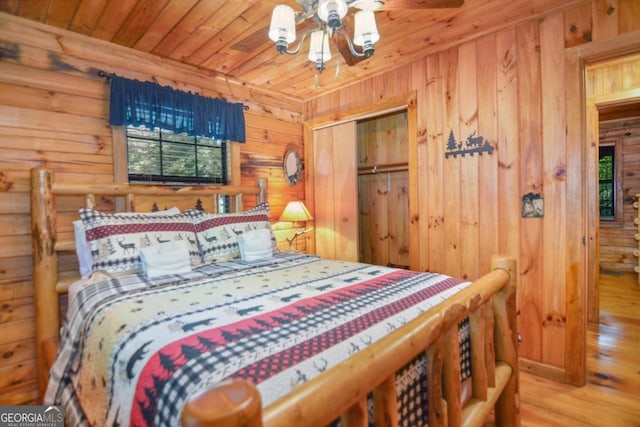 bedroom featuring light wood-type flooring, wooden ceiling, and a closet