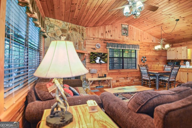 living room with ceiling fan with notable chandelier, wooden ceiling, and wooden walls