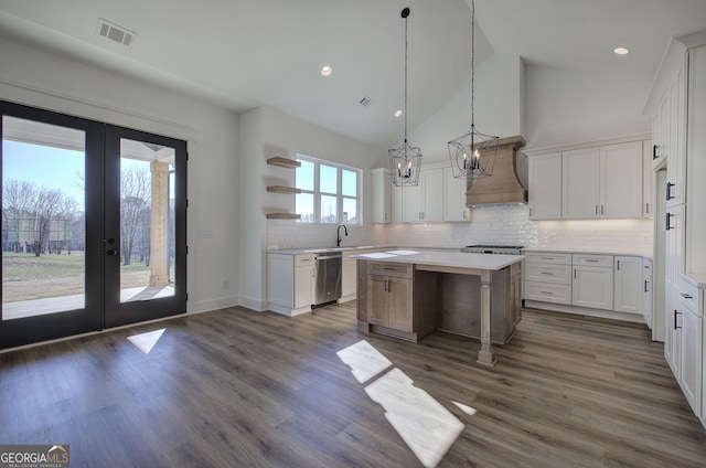 kitchen featuring white cabinets, french doors, a kitchen island, and stainless steel dishwasher