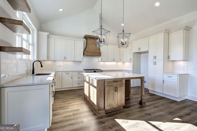 kitchen featuring a center island, dark wood-type flooring, high vaulted ceiling, white cabinets, and custom range hood