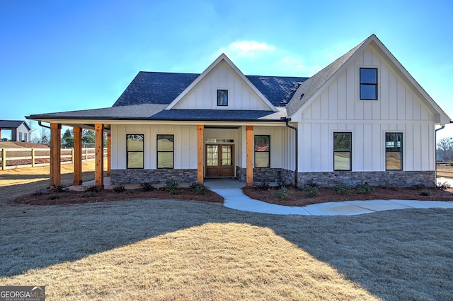 modern inspired farmhouse with covered porch, a front yard, and french doors