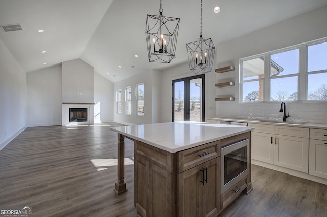 kitchen featuring stainless steel microwave, french doors, sink, dark hardwood / wood-style floors, and white cabinets