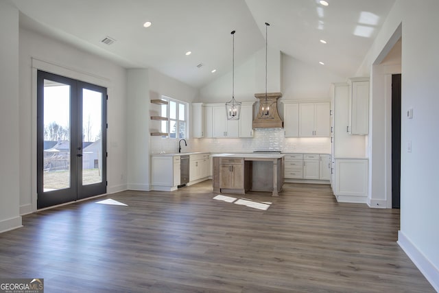 kitchen featuring pendant lighting, a center island, french doors, decorative backsplash, and white cabinetry