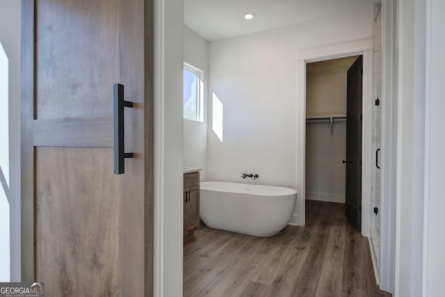 bathroom featuring a bathing tub, vanity, and hardwood / wood-style flooring