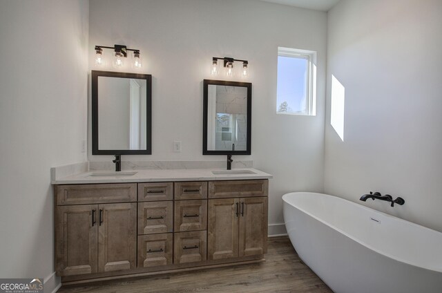 bathroom featuring hardwood / wood-style floors, a bathtub, and vanity