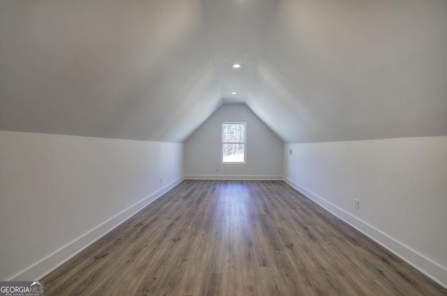 additional living space featuring vaulted ceiling and dark hardwood / wood-style floors