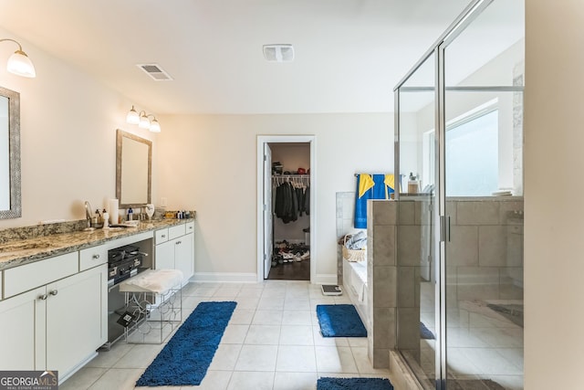 4051 Rotterdam Pass, Hampton, GA 30228 - full bathroom with double vanity, a shower stall, a bath, a spacious closet, and baseboards