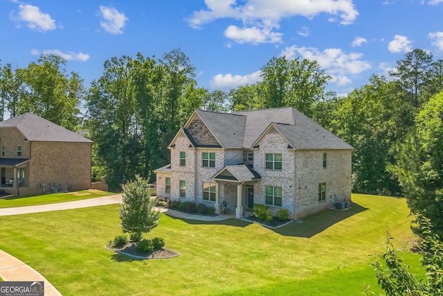 4051 Rotterdam Pass, Hampton, GA 30228 - view of front of home with a front lawn, stone siding, and central AC