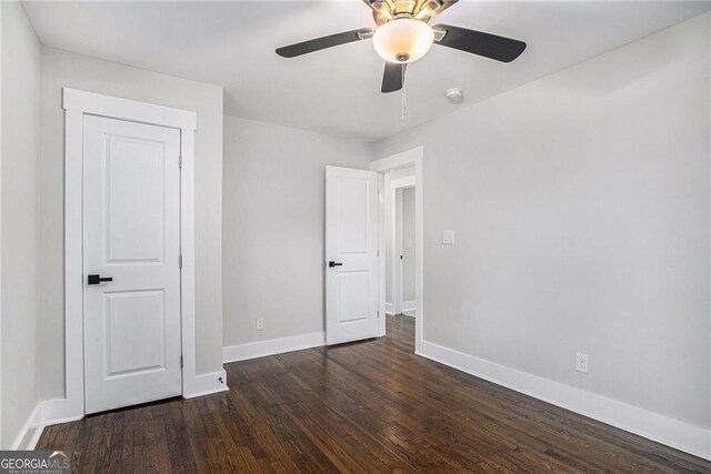 empty room featuring dark wood-type flooring and ceiling fan