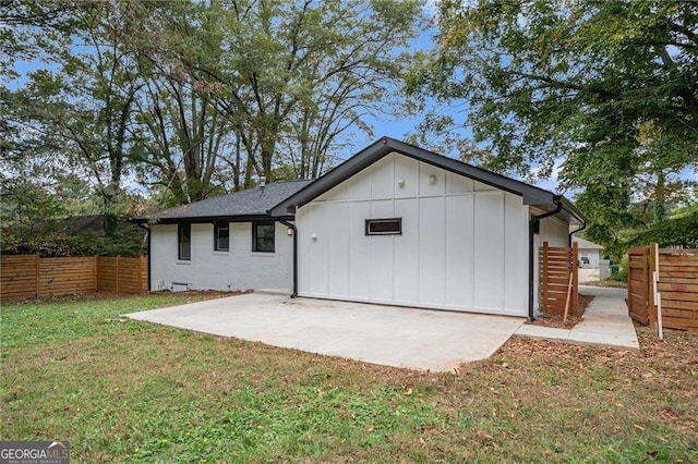 back of house with a patio and a yard