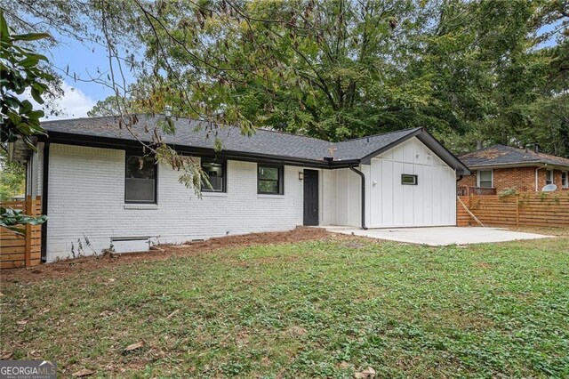 back of house with a lawn and a patio area