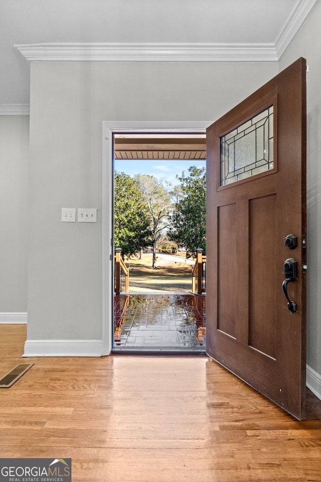 foyer entrance featuring light wood-type flooring and ornamental molding