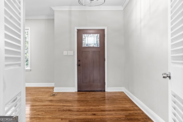 foyer featuring hardwood / wood-style floors, a chandelier, and ornamental molding