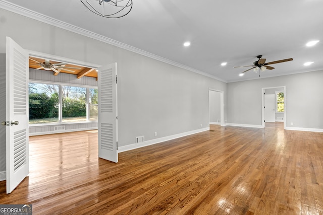 unfurnished living room featuring ceiling fan with notable chandelier, wood-type flooring, and a wealth of natural light