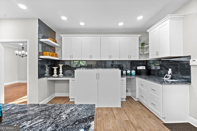 kitchen featuring white cabinets, light wood-type flooring, and tasteful backsplash