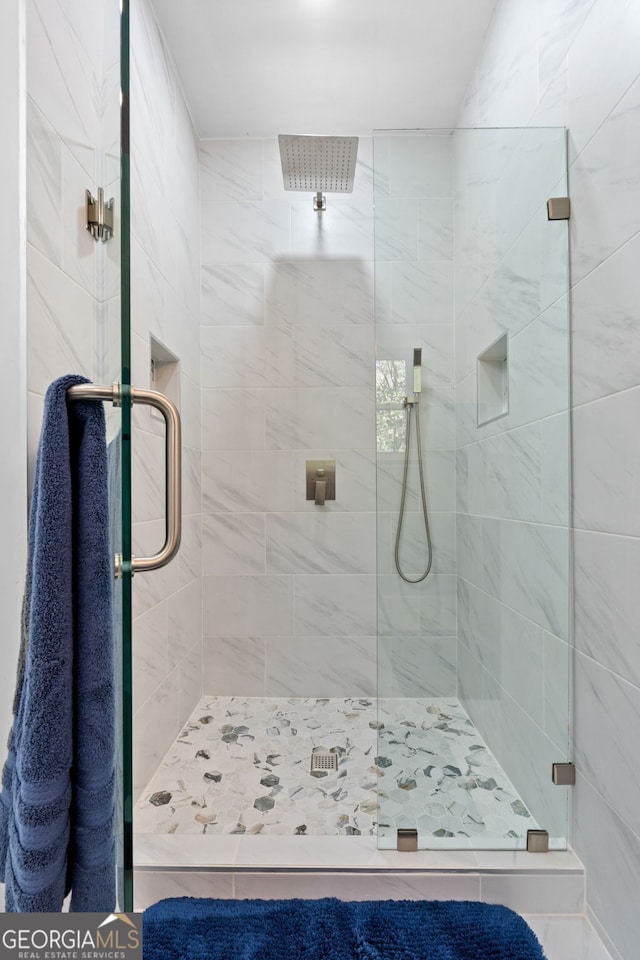 bathroom featuring a shower with shower door