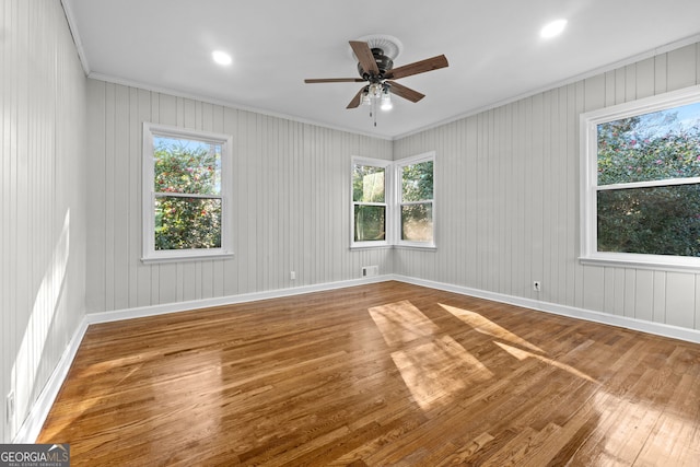 spare room with hardwood / wood-style floors, ceiling fan, and ornamental molding