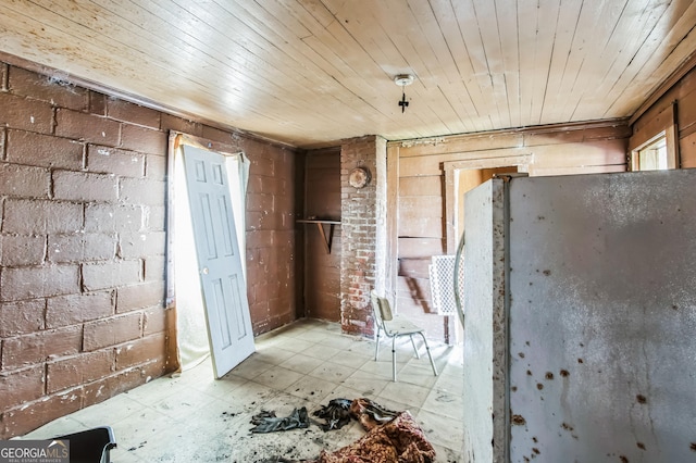 miscellaneous room with wooden ceiling and brick wall