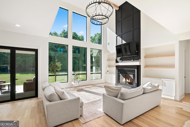 1757 Traditions Way, Jefferson, GA 30549 - living room featuring a large fireplace, a healthy amount of sunlight, and light hardwood / wood-style flooring