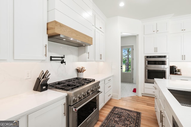 1757 Traditions Way, Jefferson, GA 30549 - kitchen with tasteful backsplash, white cabinetry, stainless steel appliances, and light hardwood / wood-style floors