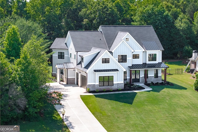 view of front of home featuring a front lawn, a porch, and a garage