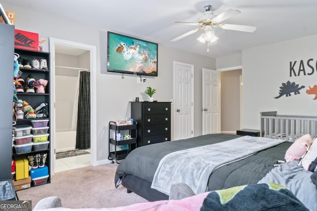 bedroom with connected bathroom, ceiling fan, and light colored carpet