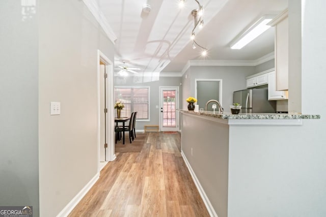 interior space featuring light wood-type flooring, ornamental molding, and sink