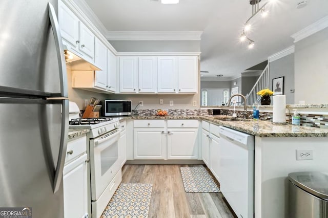 kitchen featuring white cabinetry, sink, stainless steel appliances, light stone counters, and kitchen peninsula