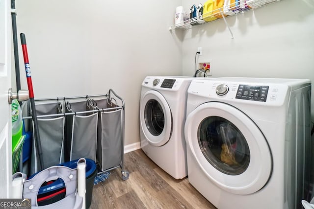 clothes washing area featuring washer and clothes dryer and hardwood / wood-style flooring