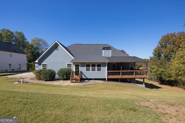 rear view of house featuring a yard and a deck