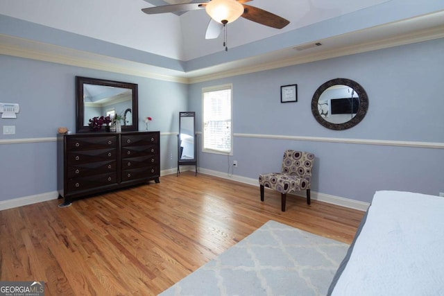 interior space with ceiling fan, a towering ceiling, wood-type flooring, and ornamental molding