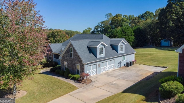 view of front of home with a front yard, a garage, and central AC unit