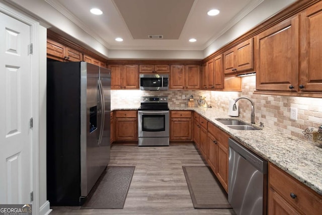 kitchen with decorative backsplash, light stone countertops, sink, and stainless steel appliances