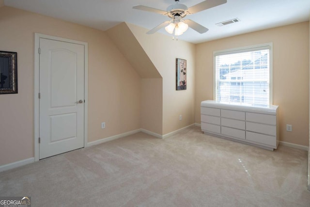 bonus room with ceiling fan and light colored carpet