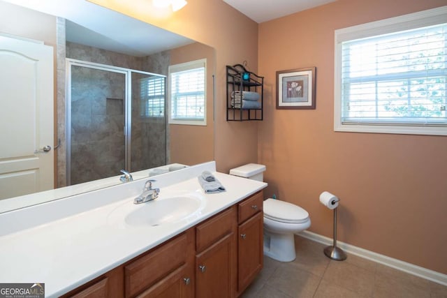 bathroom featuring tile patterned floors, vanity, toilet, and a shower with door