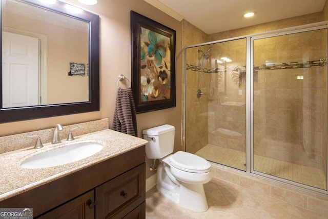 bathroom featuring tile patterned floors, vanity, a shower with shower door, and toilet