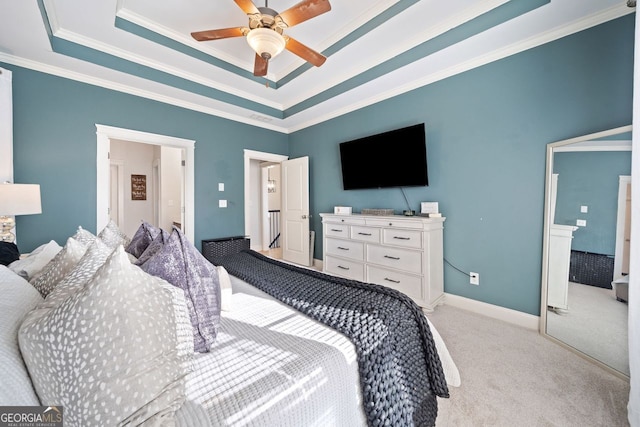 carpeted bedroom with a raised ceiling, ceiling fan, and ornamental molding