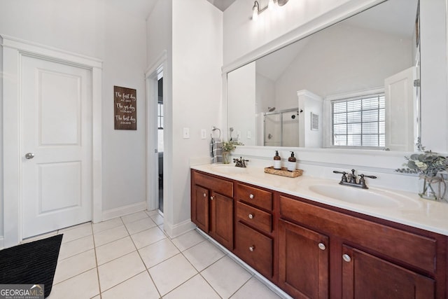 bathroom with tile patterned flooring, lofted ceiling, a shower with door, and vanity