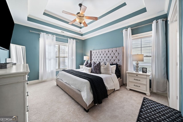 bedroom with light colored carpet, a raised ceiling, and ceiling fan