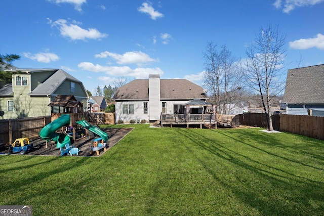 rear view of house featuring a gazebo, a lawn, and a wooden deck