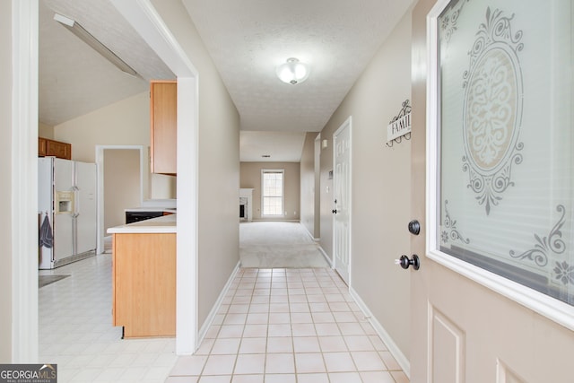 hallway with light carpet and a textured ceiling