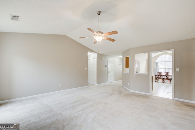 carpeted empty room featuring vaulted ceiling and ceiling fan