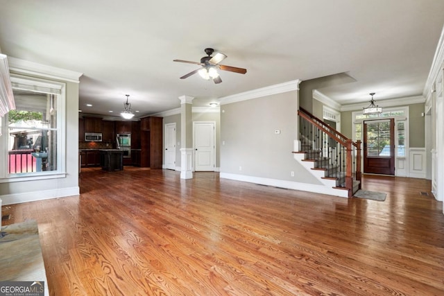 unfurnished living room with wood-type flooring, ceiling fan, and ornamental molding