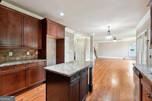 kitchen featuring ornate columns, light stone counters, a center island, and dishwasher