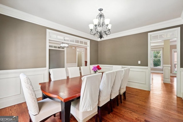 dining area featuring ornamental molding, a notable chandelier, and hardwood / wood-style floors