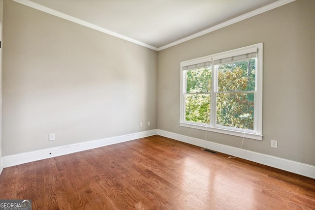 empty room featuring crown molding and hardwood / wood-style floors